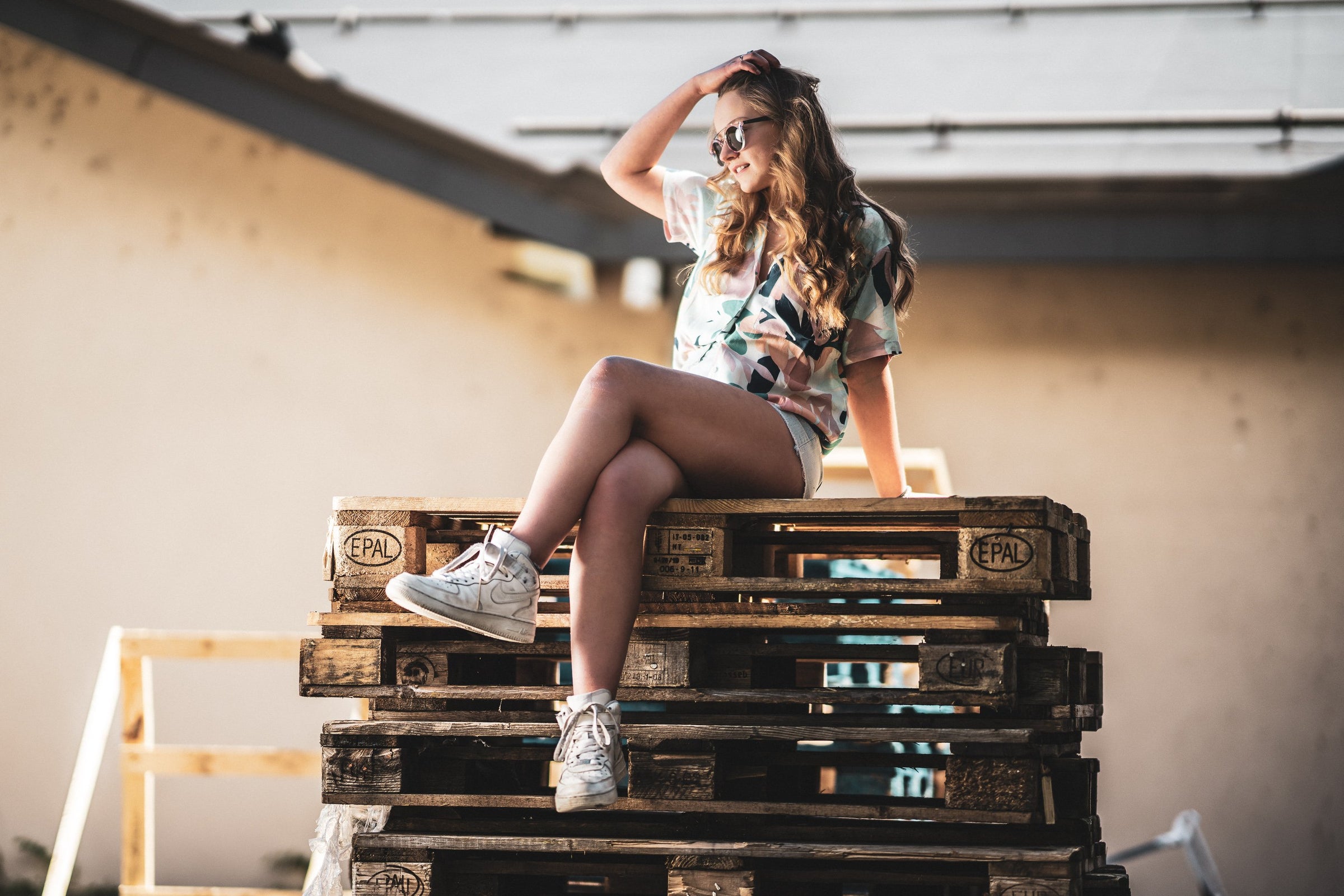 Jeune femme portant les Loubsol Nebraska sur un empilement de palettes industrielles